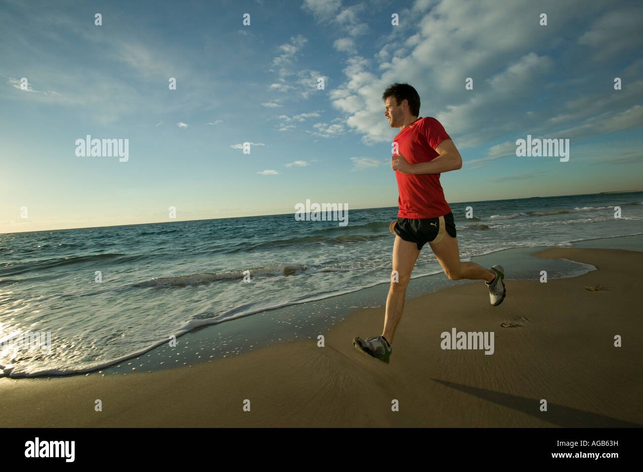 Runner maschio sulla spiaggia Foto Stock