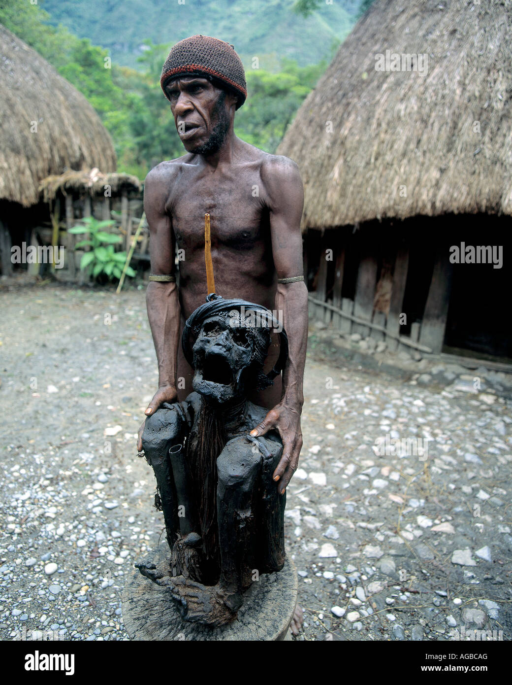 Uomo con un antenato mummificato, Dani Tribe, Irian Jaya, Indonesia Foto Stock