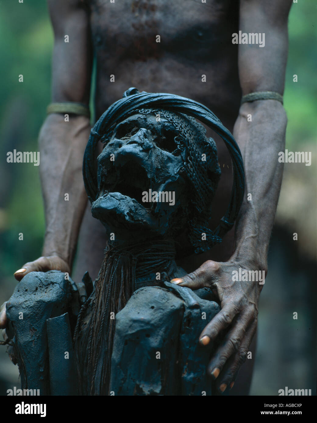 Uomo con un antenato mummificato, Dani Tribe, Irian Jaya, Indonesia Foto Stock