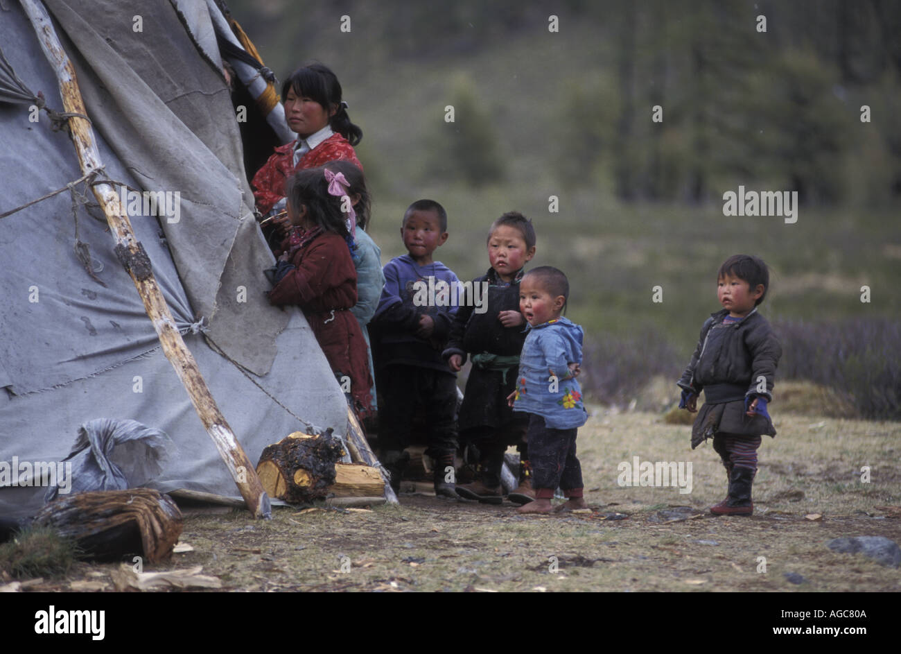 Tsaatan famiglia al di fuori del loro teepee / casa nella Taiga Foresta Montagne Foto Stock