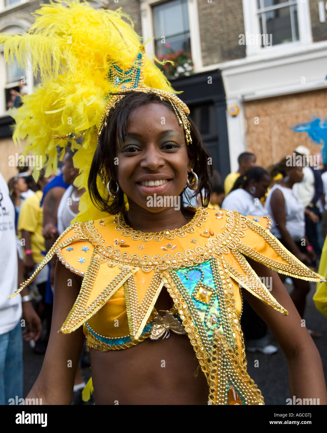 Un giovane, bella ragazza nera in un colorato di giallo vestito con una piuma copricapo a Notting Hill Carinval 2007. Foto Stock