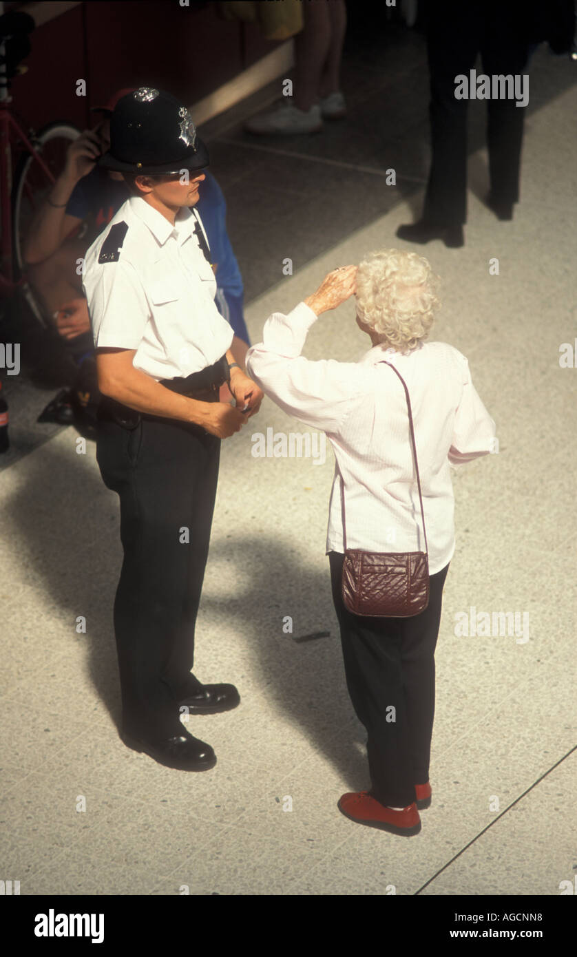 Uomo di polizia a parlare alla signora anziana, Liverpool Street Station di Londra, Regno Unito Foto Stock