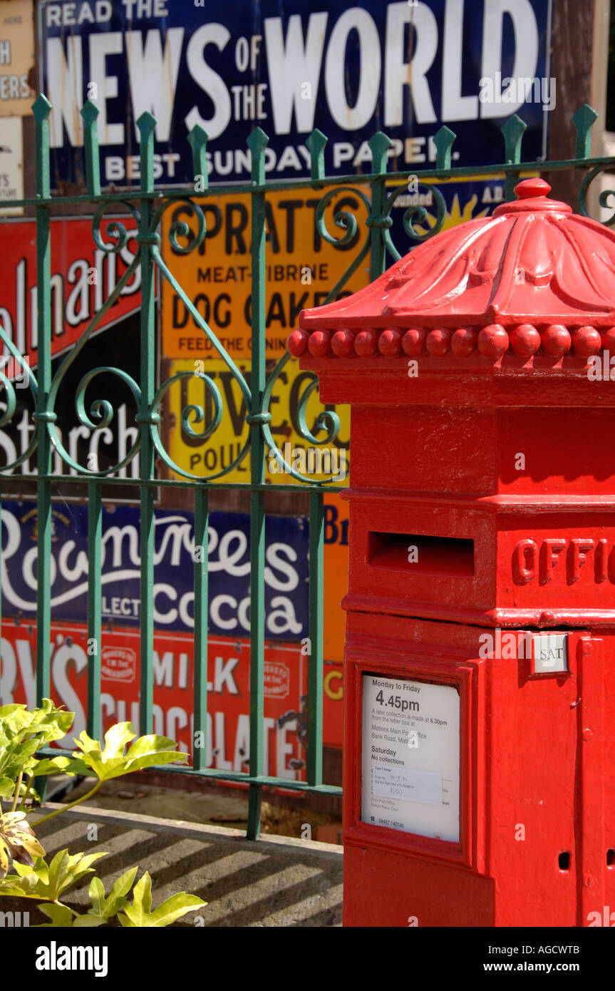 Vecchio rosso Post Box contro il vecchio pre guerra segni di metallo a Crich Museo dei Trasporti Foto Stock