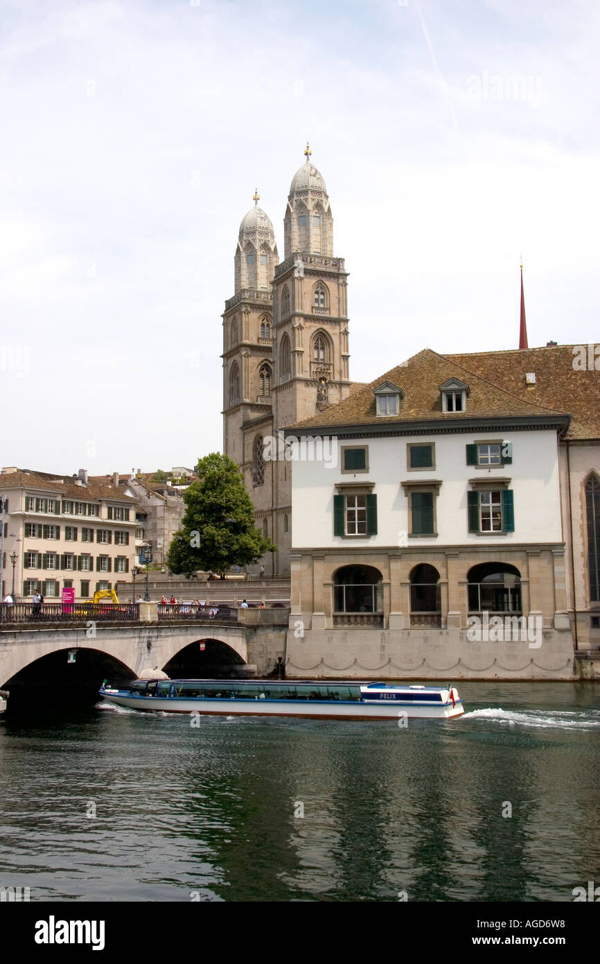 Tour in barca passa sotto il Munster ponte che attraversa il fiume Limmat a Zurigo, Svizzera con le torri della chiesa Grossmunster. Foto Stock