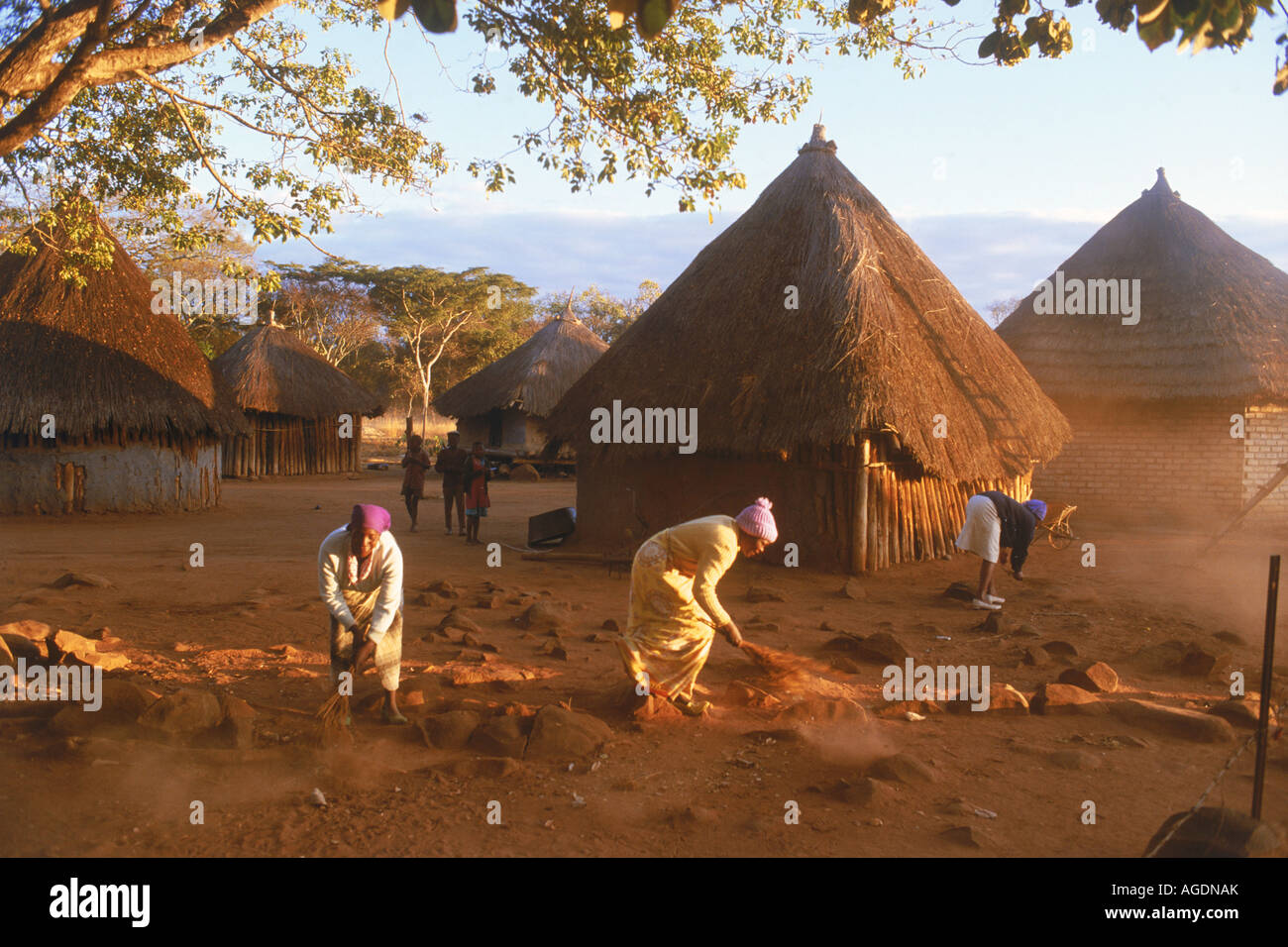 Piccolo borgo con le donne e le malghe di sunrise in Zimbabwe Africa Foto Stock