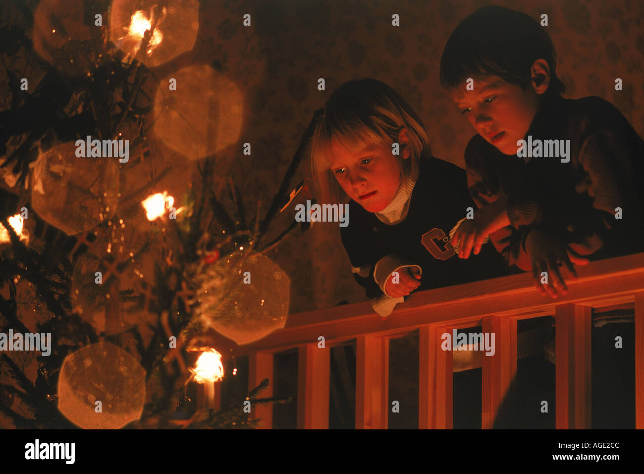 Fratello e Sorella staring al albero di Natale Foto Stock