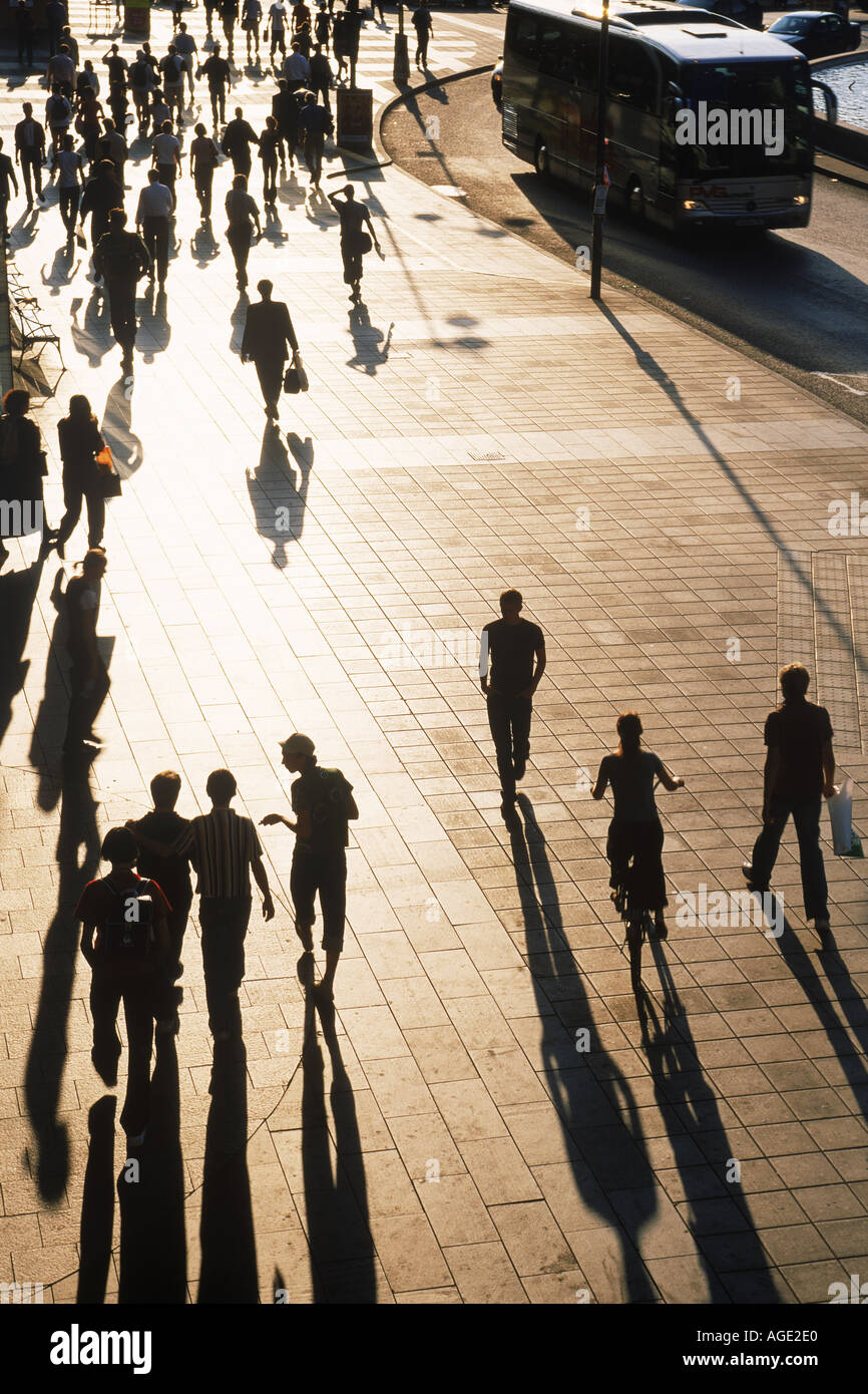 Persone e ombre lunghe in condizioni di scarsa luce sul marciapiede di Stoccolma Foto Stock