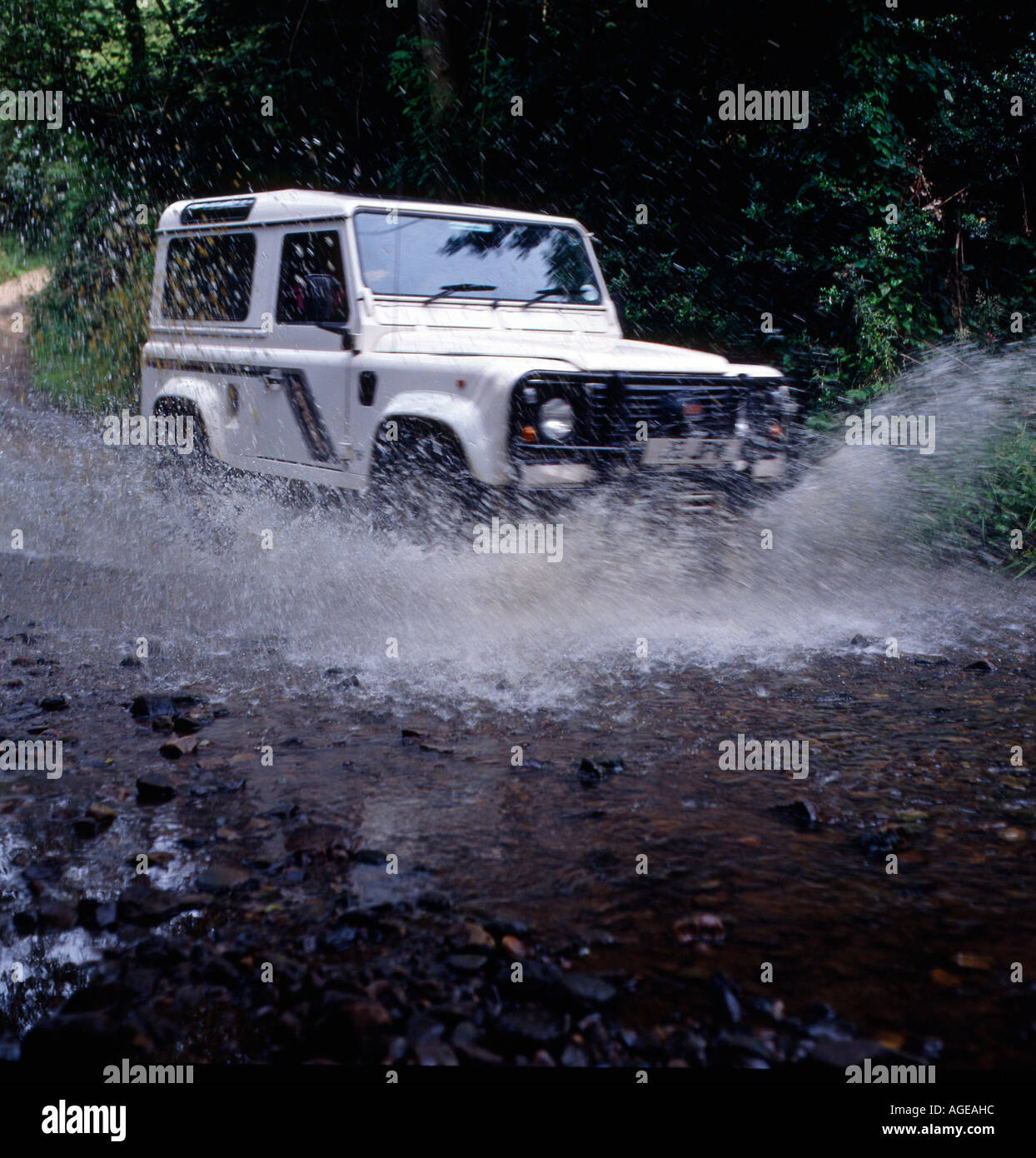 Land Rover 4 x 4 schizzi attraverso una Ford (acqua) Foto Stock