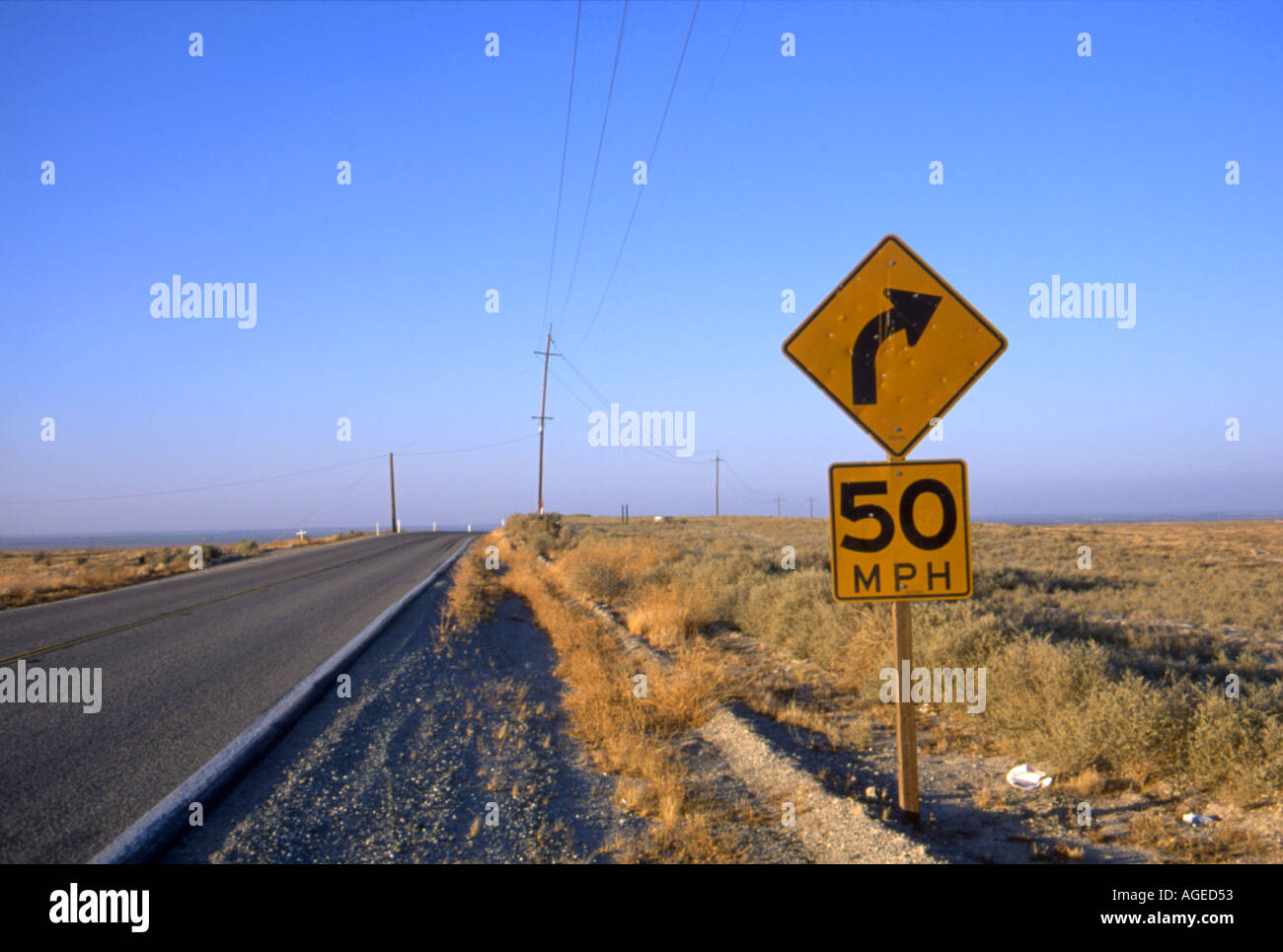 Long lonely Deserto della California tratte autostradali in distanza, una 50mph a destra segno in primo piano Foto Stock