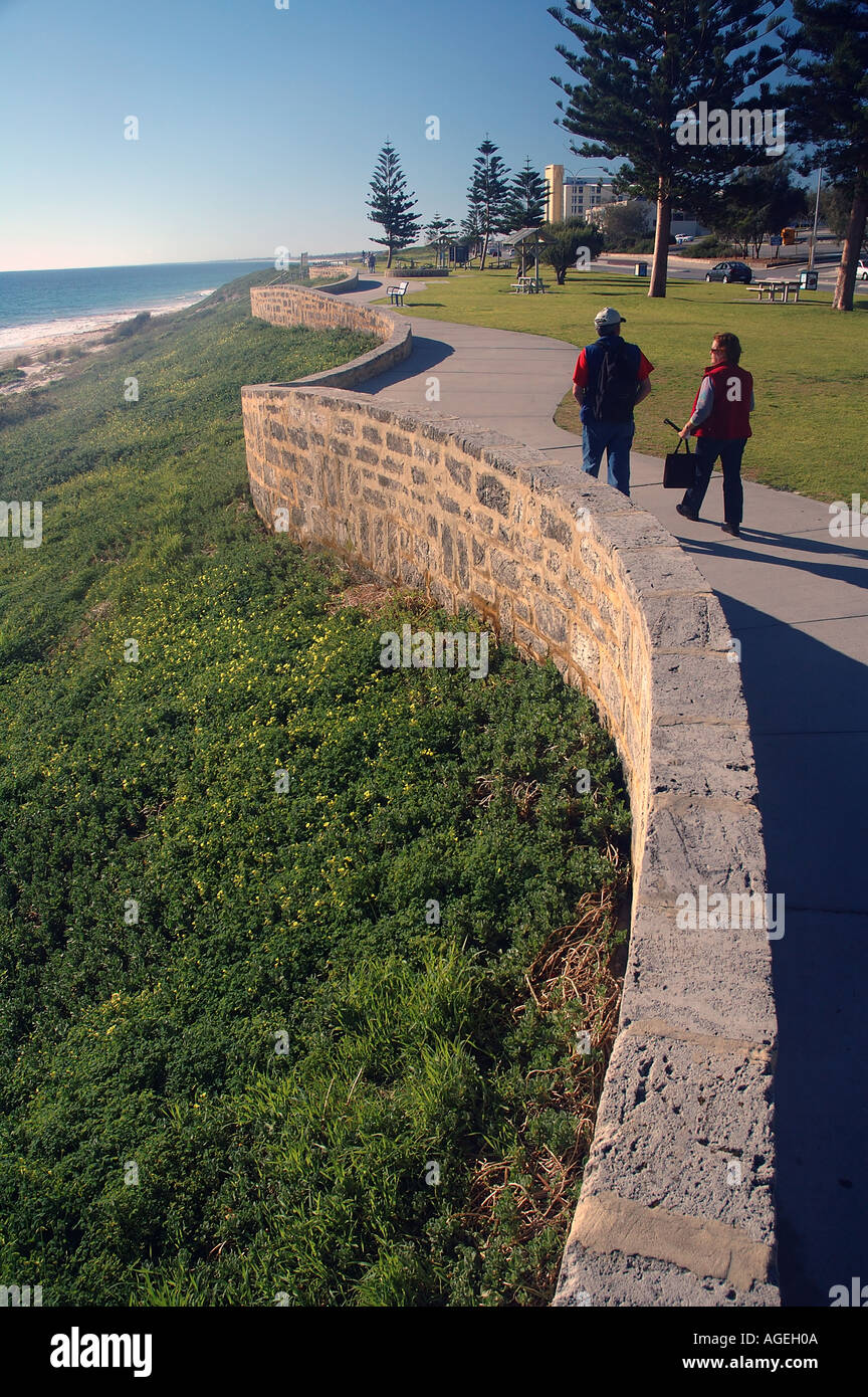 Giovane camminare lungo la passeggiata sulla spiaggia Cottesloe Beach Perth Western Australia MR Foto Stock