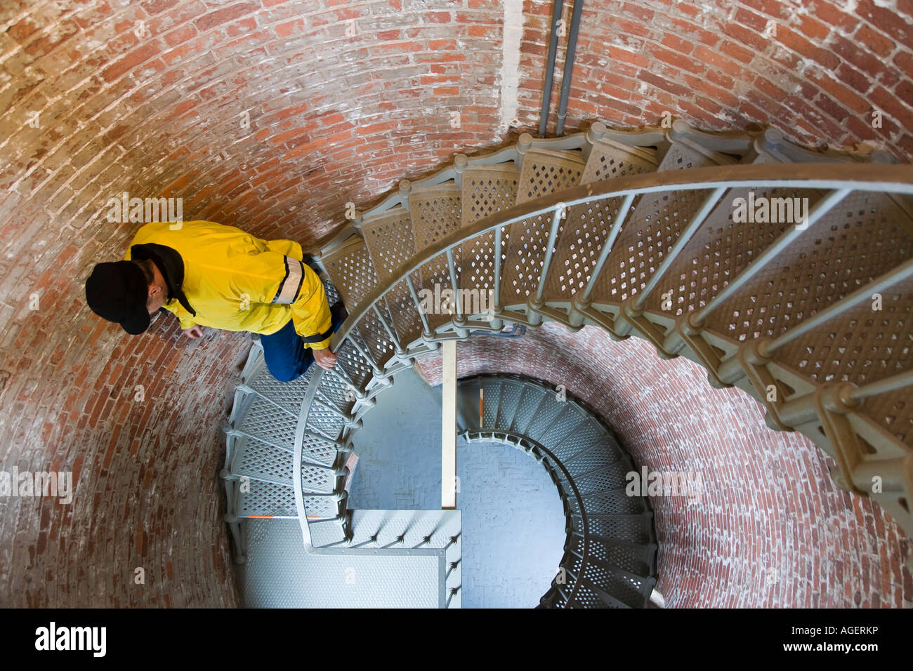 L'uomo discende scalinata circolare all'interno di Cape Blanco Light house Oregon Foto Stock