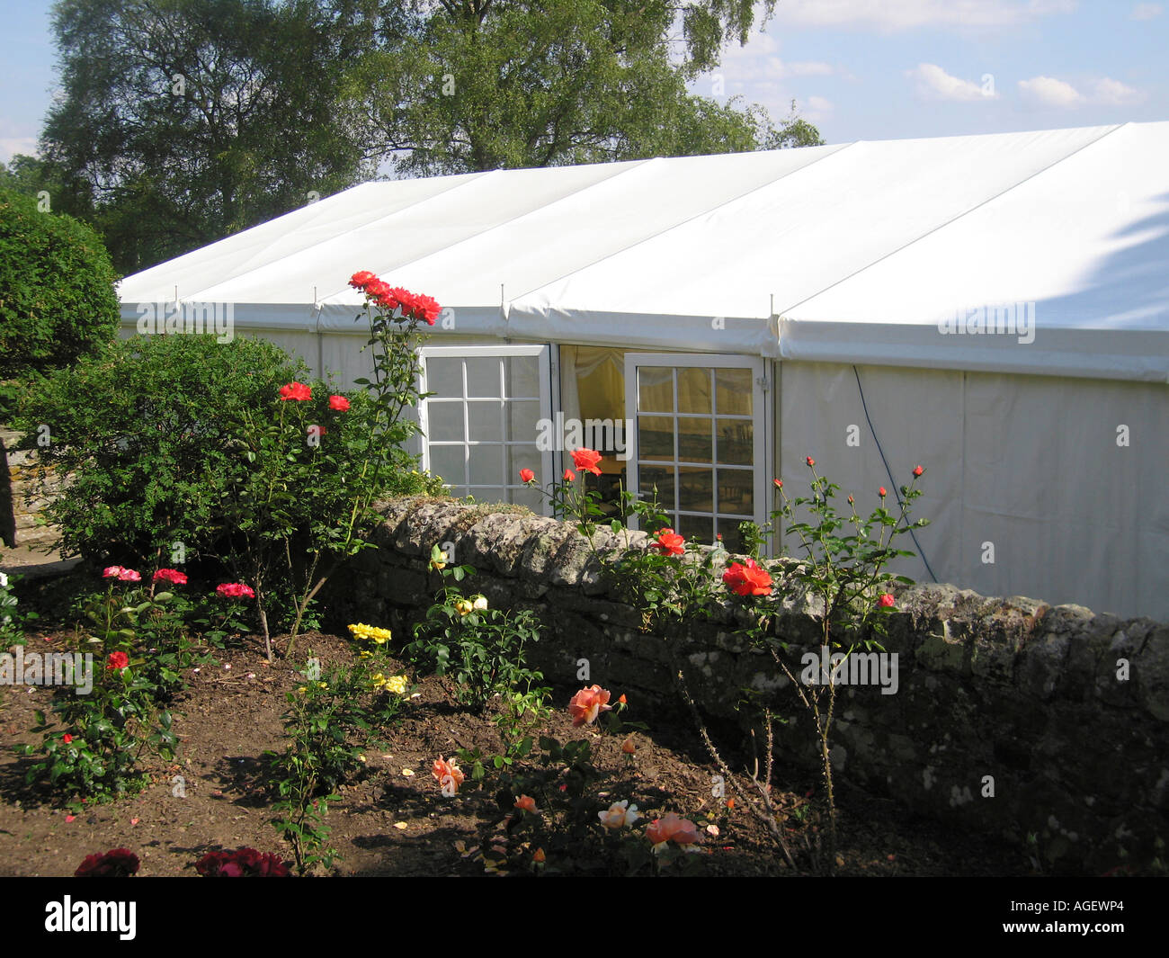 Tendone bianco con lati chiusi e porte aperte nel giardino del Northumberland prima del ricevimento di nozze Foto Stock