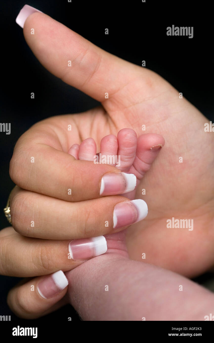 A due settimane di età Baby Femmina piede con le madri toccando a mano Foto Stock