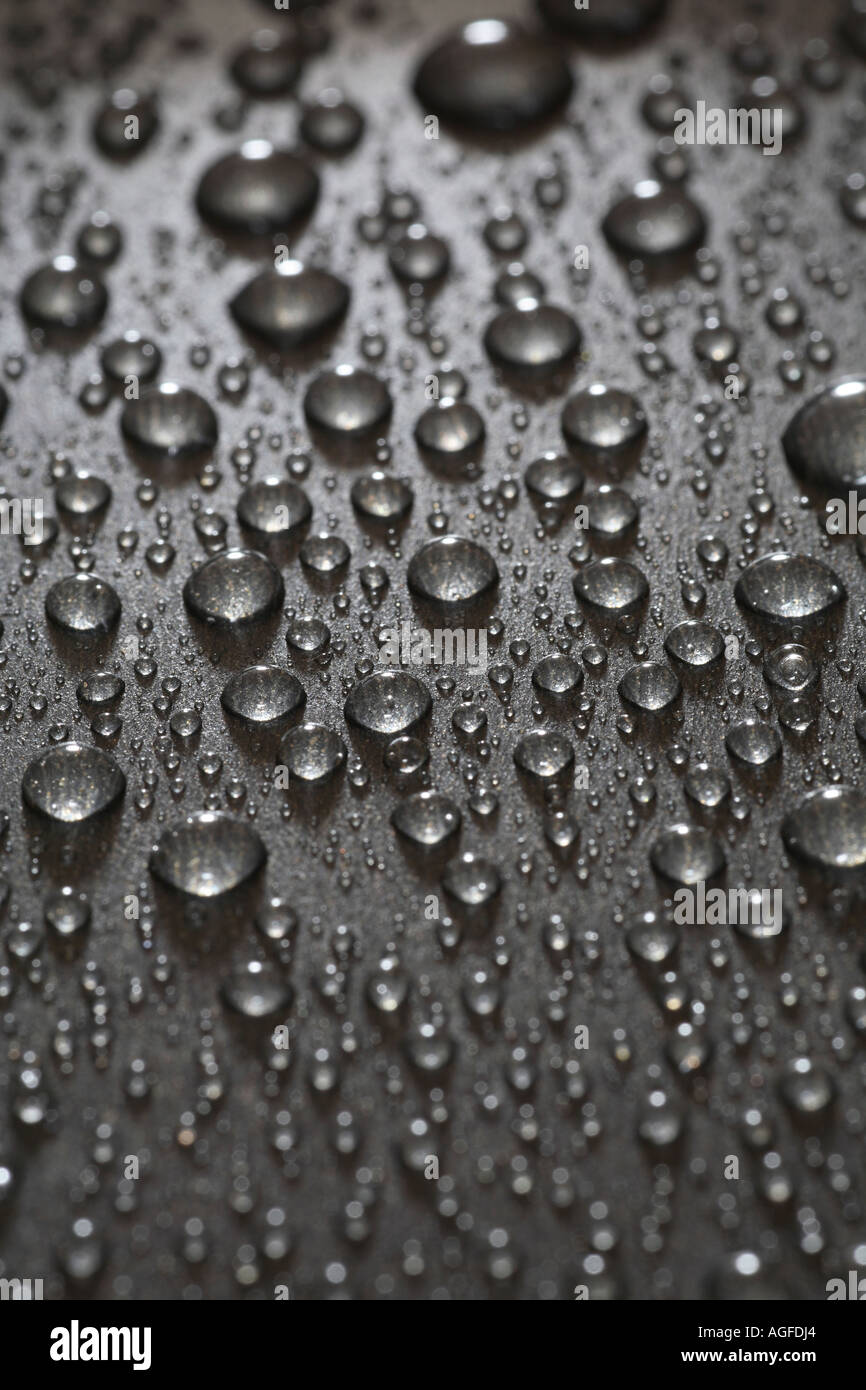 Close up di gocce di acqua sulla superficie nera. Foto Stock