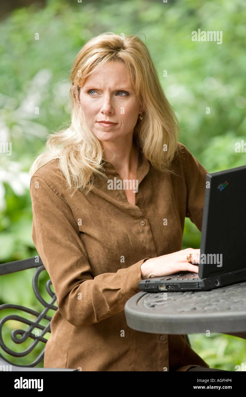 La donna al di fuori su un computer portatile Foto Stock