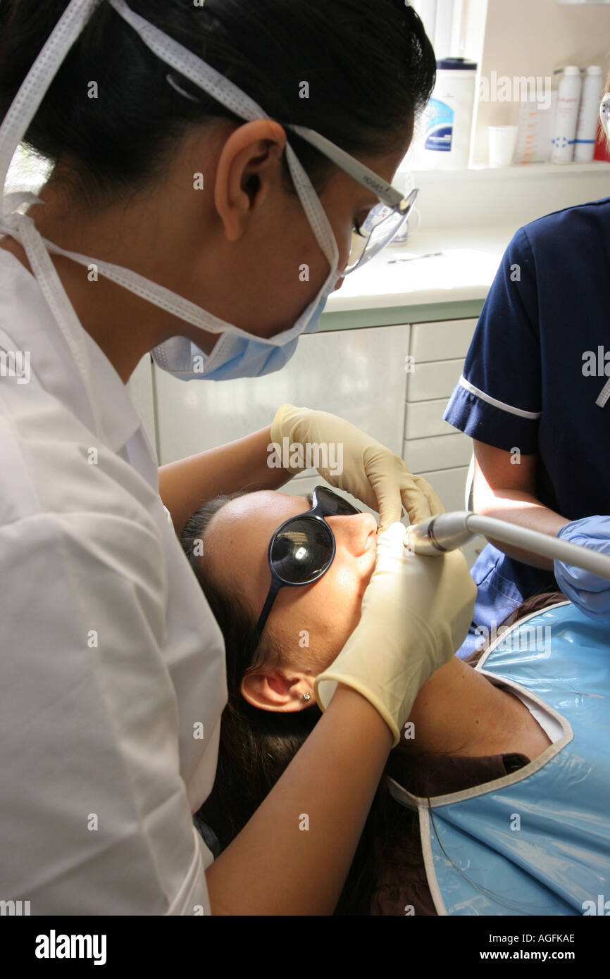 Un intervento di chirurgia dentale dentista infermiere e paziente avente un polacco Foto Stock