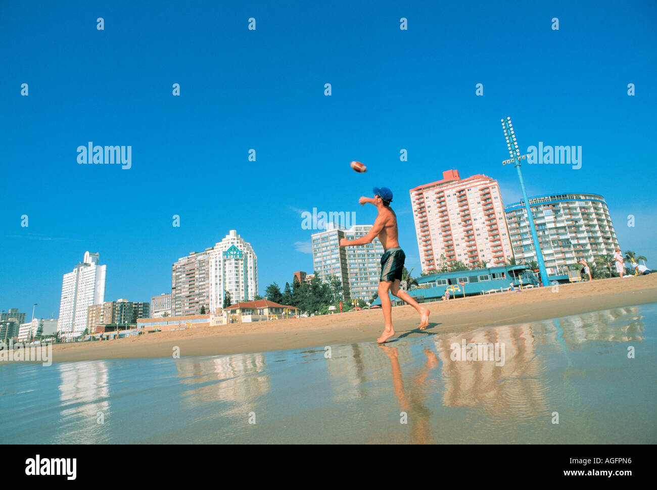 L'uomo throughing calcio sulla spiaggia, Durban, Sud Africa Foto Stock