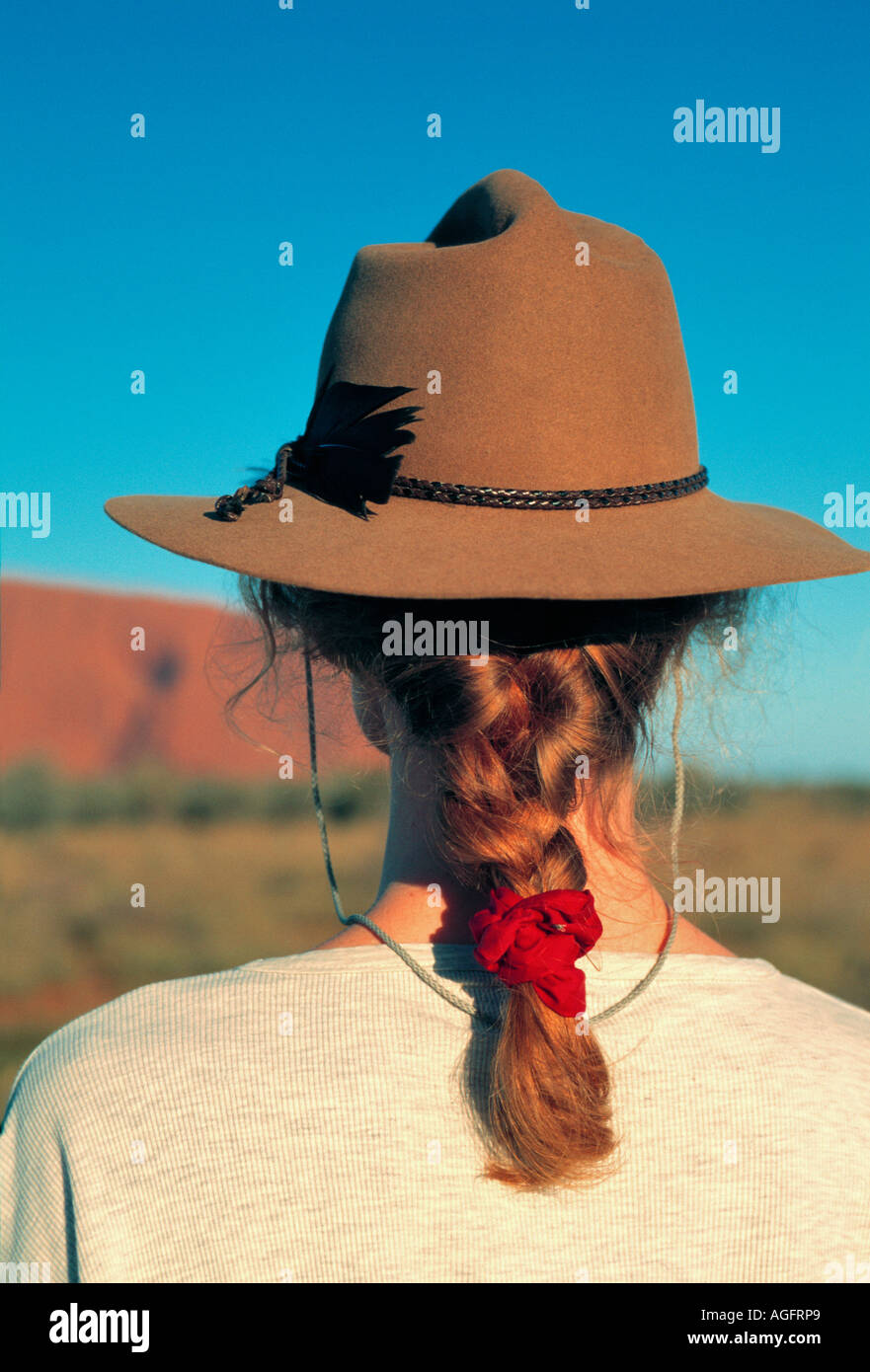Donna con cappello la visualizzazione di Ayers Rock, Territorio del Nord, l'Australia Foto Stock