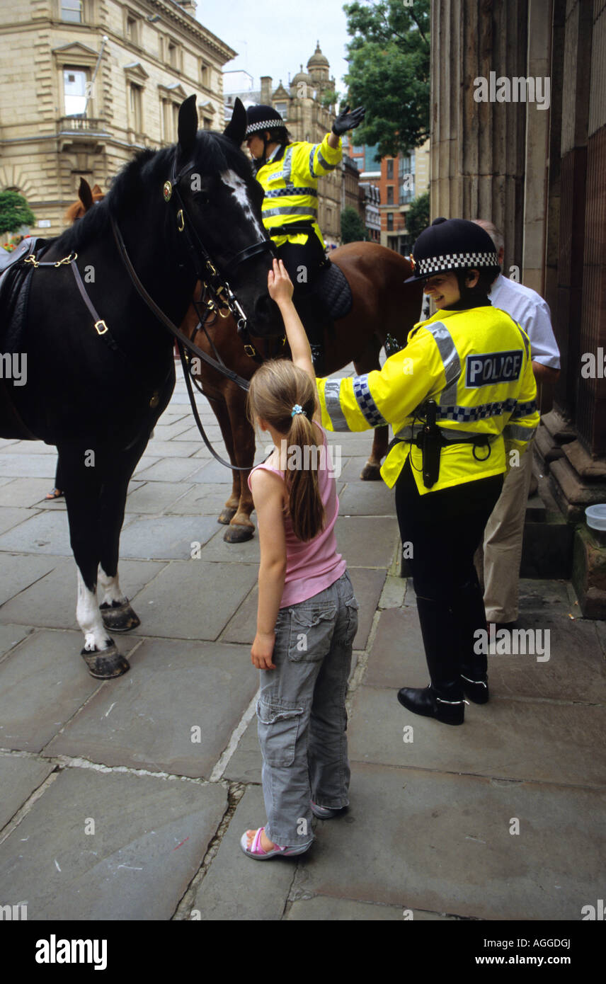Ragazza giovane con cavalli della polizia montata Foto Stock