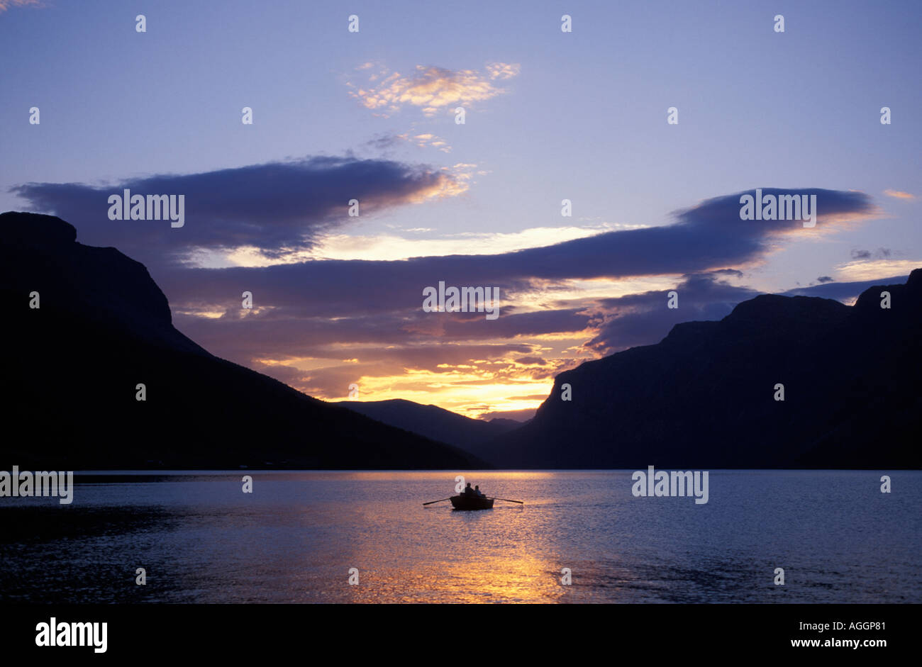 Europa Norvegia piccolo canotto in Vangsmjosa lago circondato da montagne vicino Vang al tramonto Foto Stock