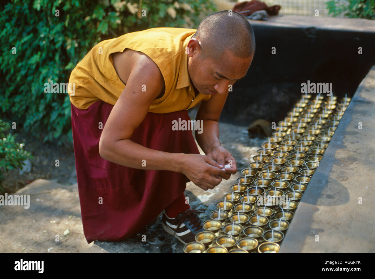 Monaco buddista di illuminazione lampade ad olio, di fronte Dhamekh Stupa, Sarnath, Uttar Pradesh, India Foto Stock