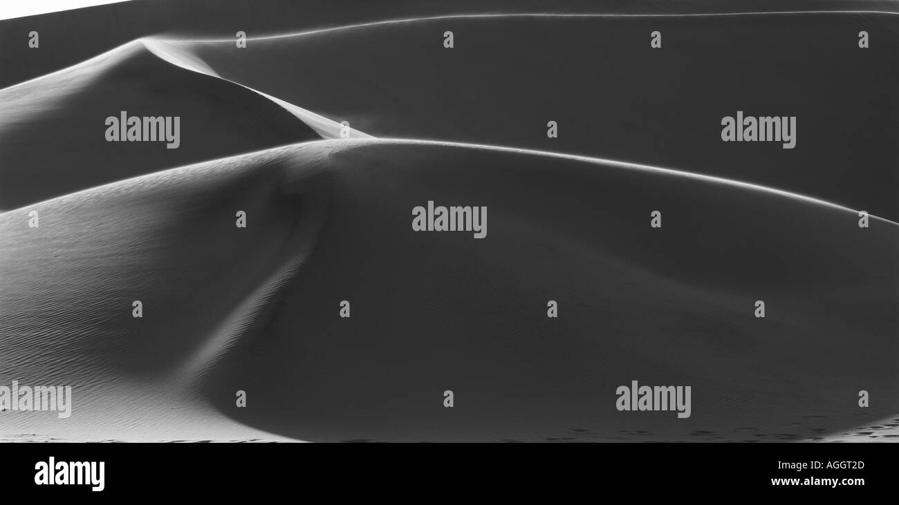 La Namibia Namib Desert impostazione sole illumina la curvatura dune di sabbia vicino alla città costiera di Walvis Bay Foto Stock