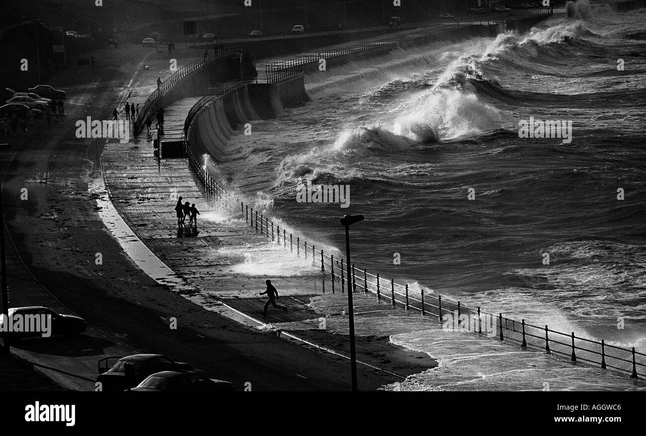 Stagliano dei gruppi di persone a piedi lungo il mare difese in Scarborough North bay Yorkshire Foto Stock