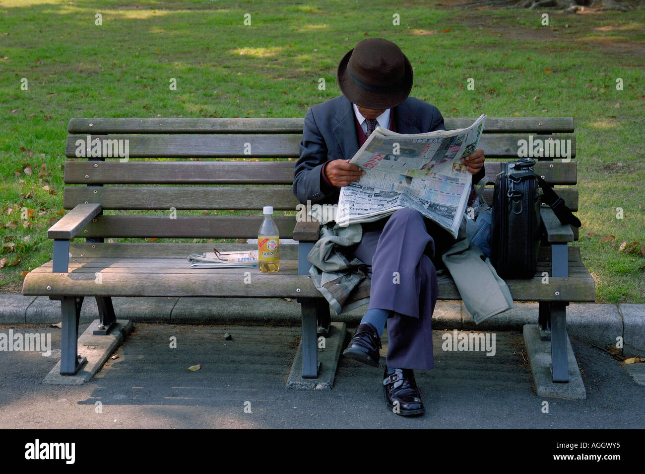 Il vecchio uomo su una panchina nel parco, Tokyo, Giappone Foto Stock