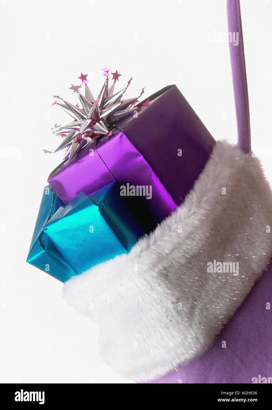 Diversi presenta nella parte superiore di un tessuto lilla calza di Natale bianco con rivestimento in pelliccia sospesi contro uno sfondo bianco Foto Stock