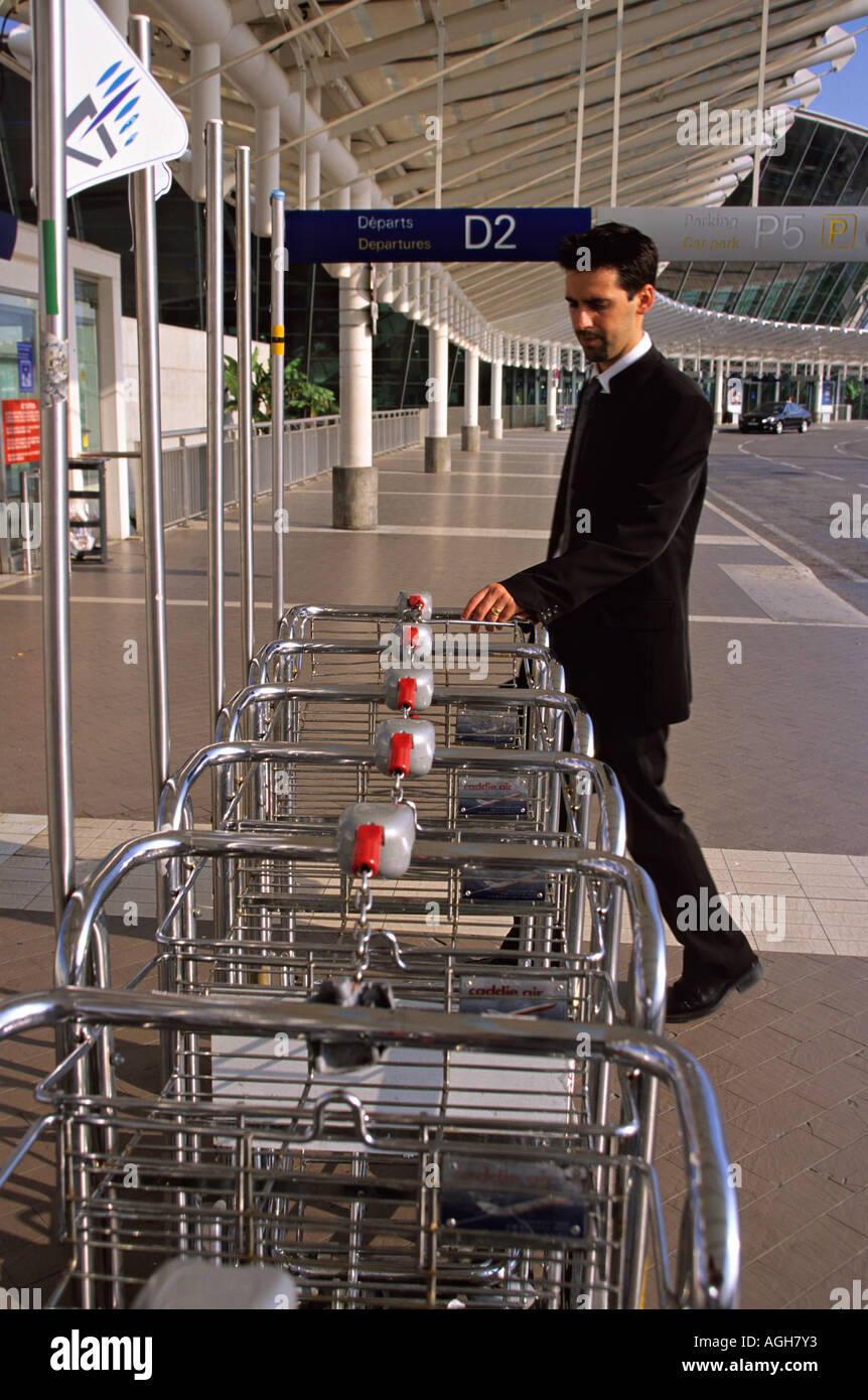 L'uomo prendendo un carrelli per bagagli all'aeroporto di Nizza Foto Stock