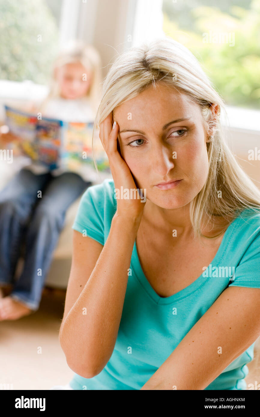 Madre cercando preoccupato con sua figlia in background Foto Stock