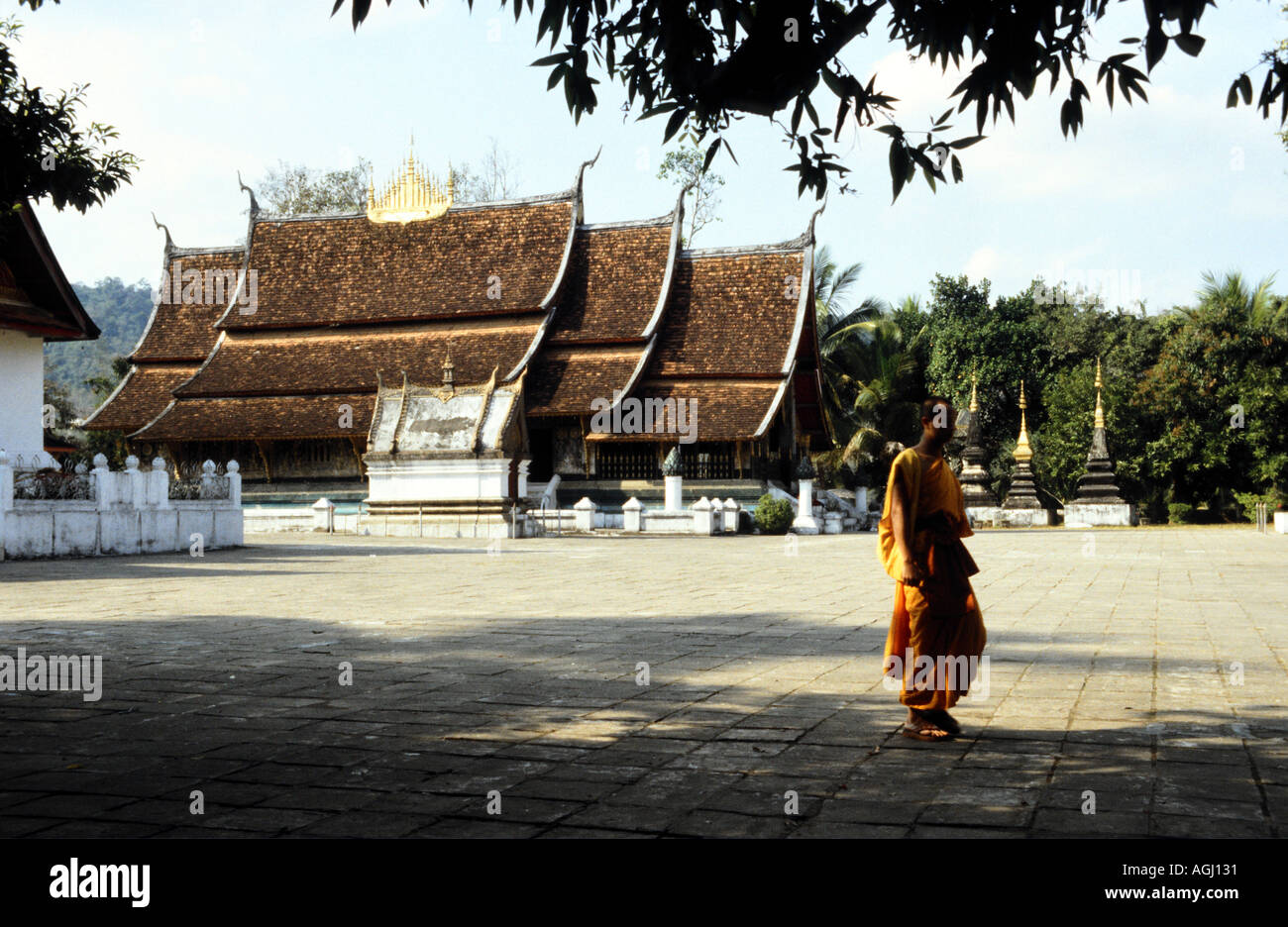 Un monaco passeggiate passato storico royal tempio di Wat Xieng Thong a Luang Prabang nel nord del Laos Foto Stock