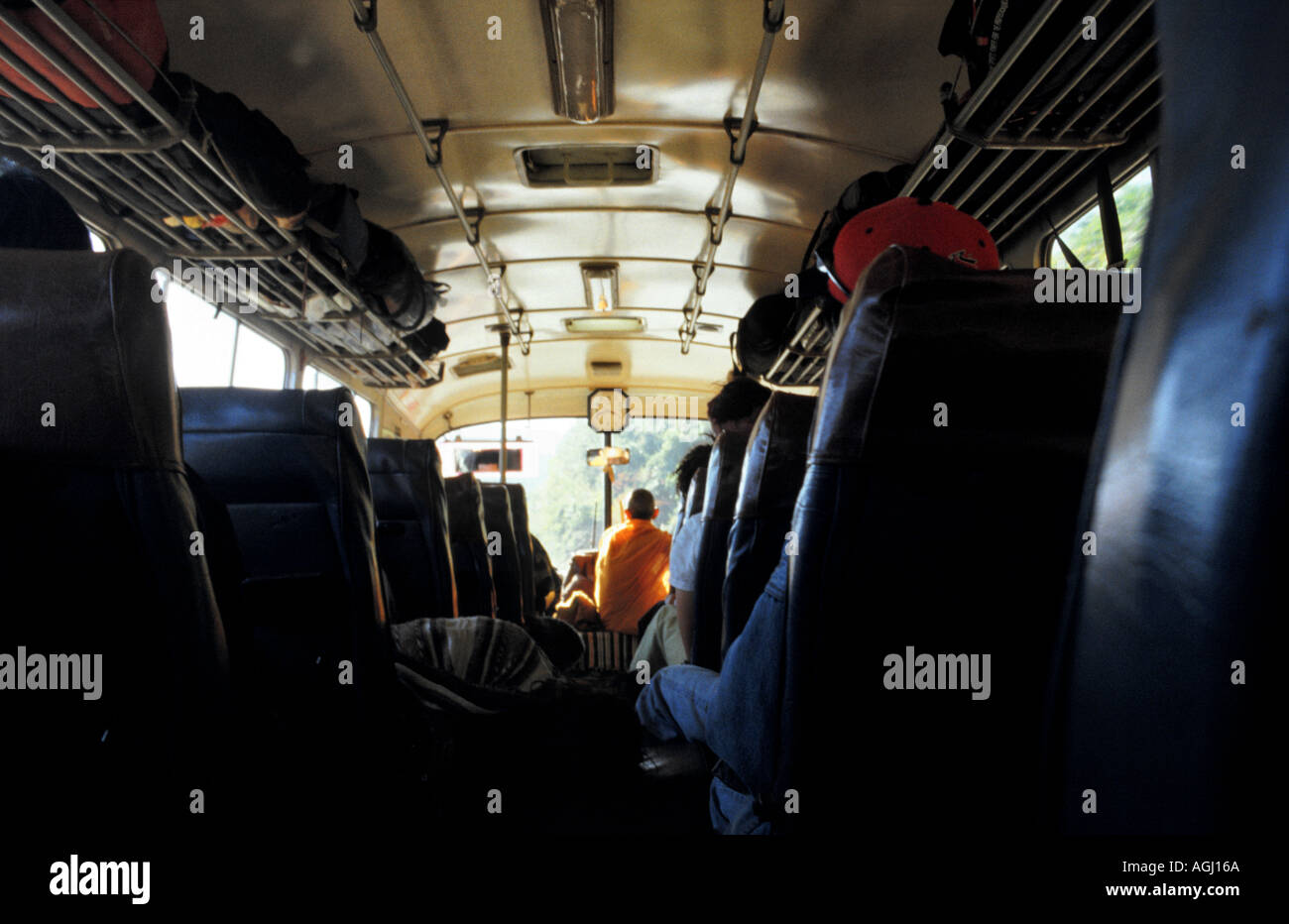 Un monaco si trova nella parte anteriore di un autobus che viaggiava da Luang Prabang a Vientiane capitale del Laos Foto Stock