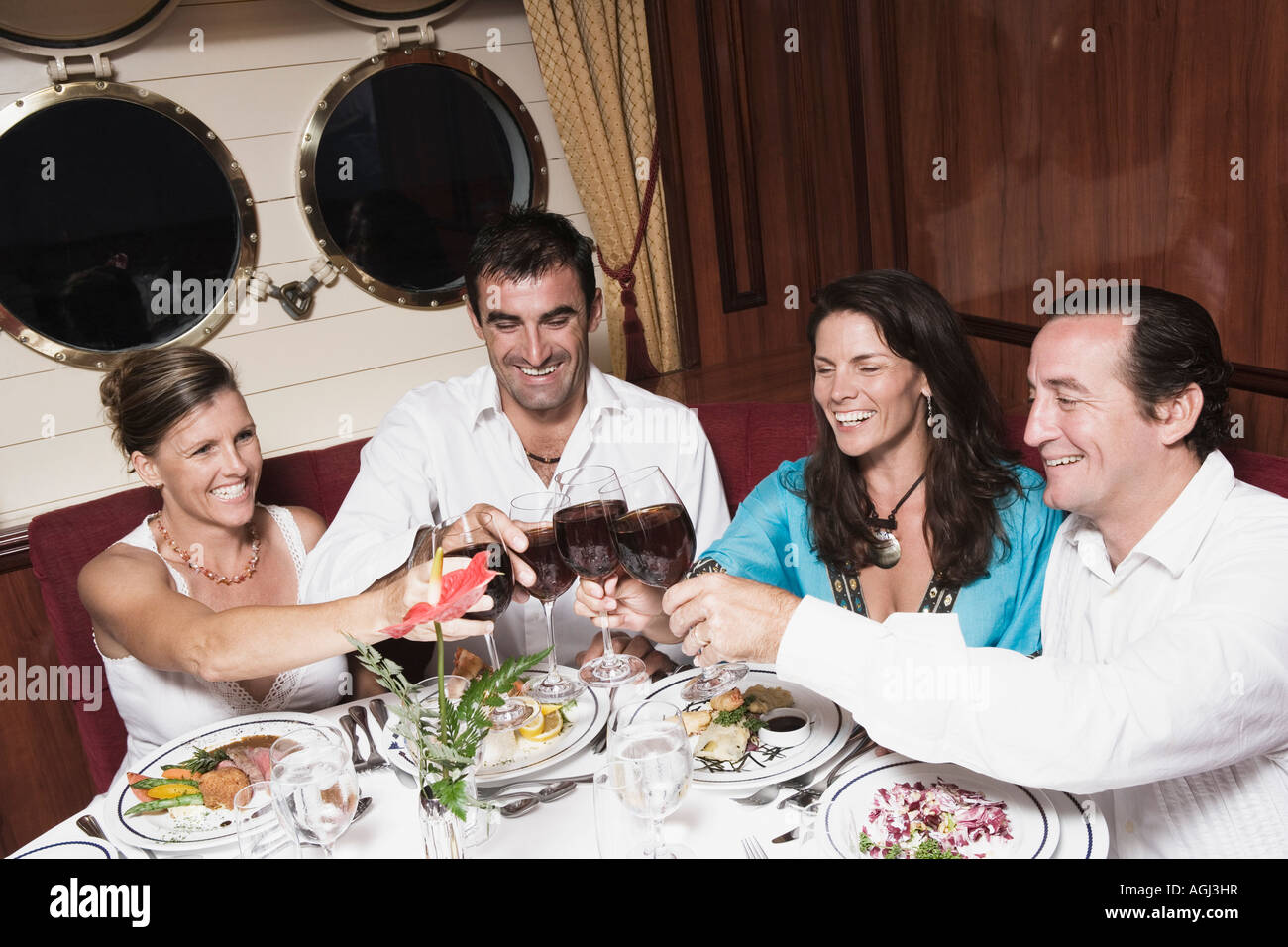 Due metà coppie di adulti la tostatura con bicchieri di vino e sorridente Foto Stock