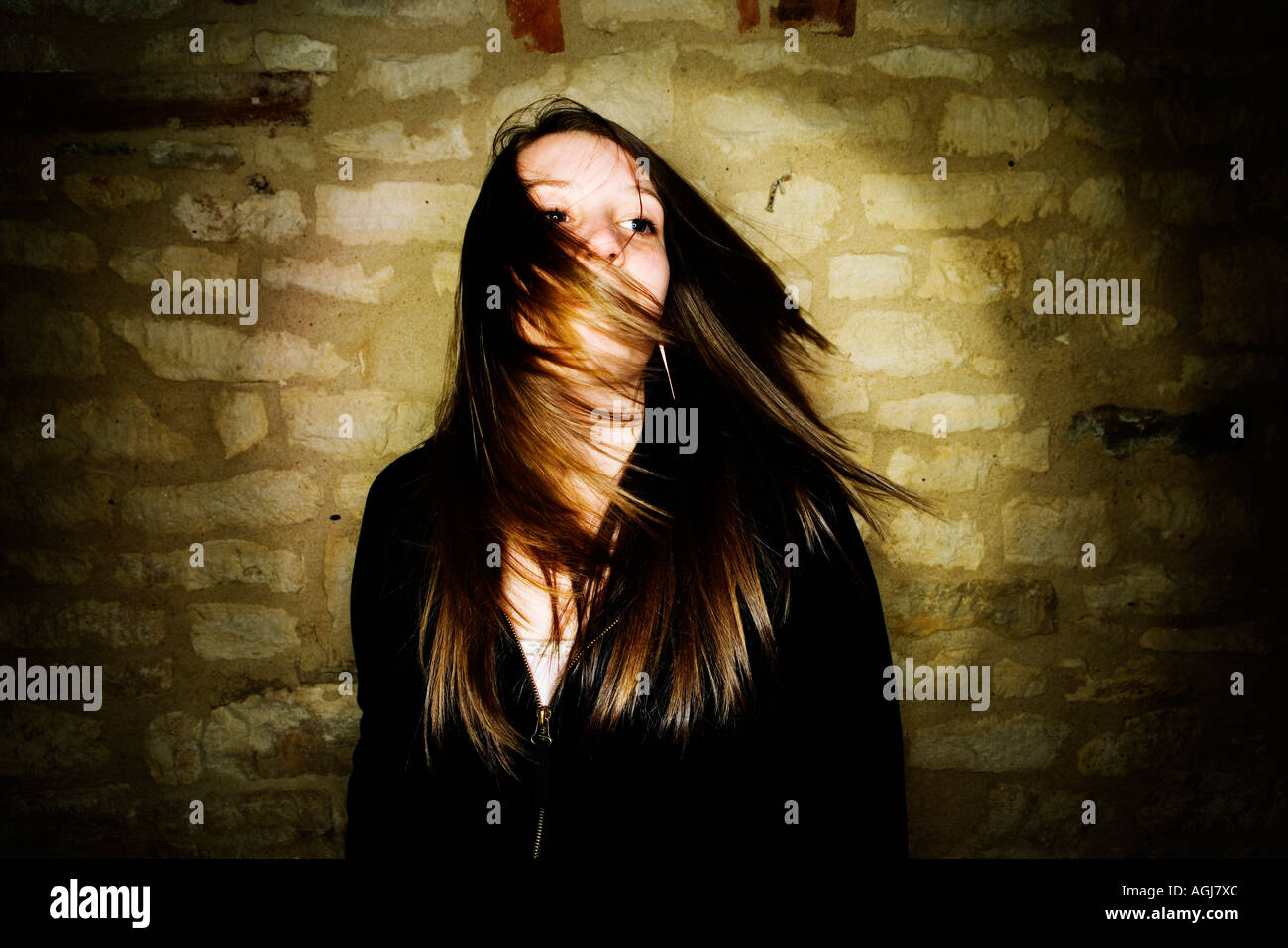 Ritratto di ragazza adolescente vestito di nero in alto e facendo oscillare i suoi capelli a lato. Foto Stock