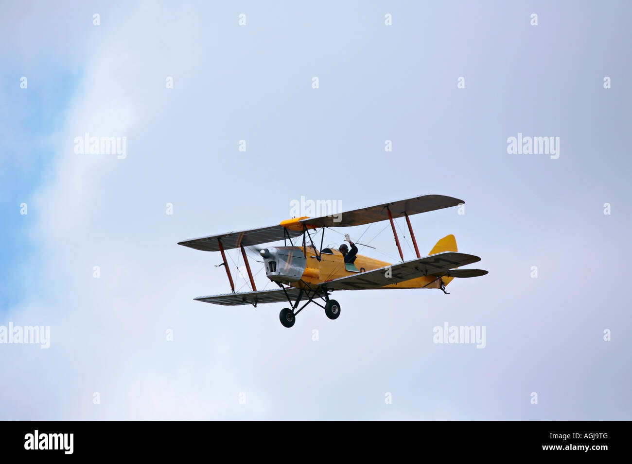 Pilota che sventola da De Havilland Tiger Moth aviotrasportato a Shoreham Airshow, Shoreham Airport, West Sussex, Inghilterra, Regno Unito Foto Stock