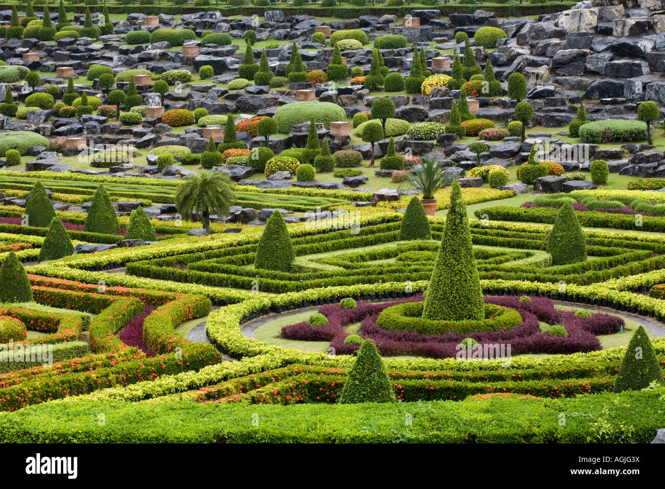 Giardino formale francese, copertura e arbusti dal design simmetrico a Suan Nong Nooch, Nongnooch Tropical Botanical Garden Resort, Chon Buri, Pattaya, Thailandia Foto Stock