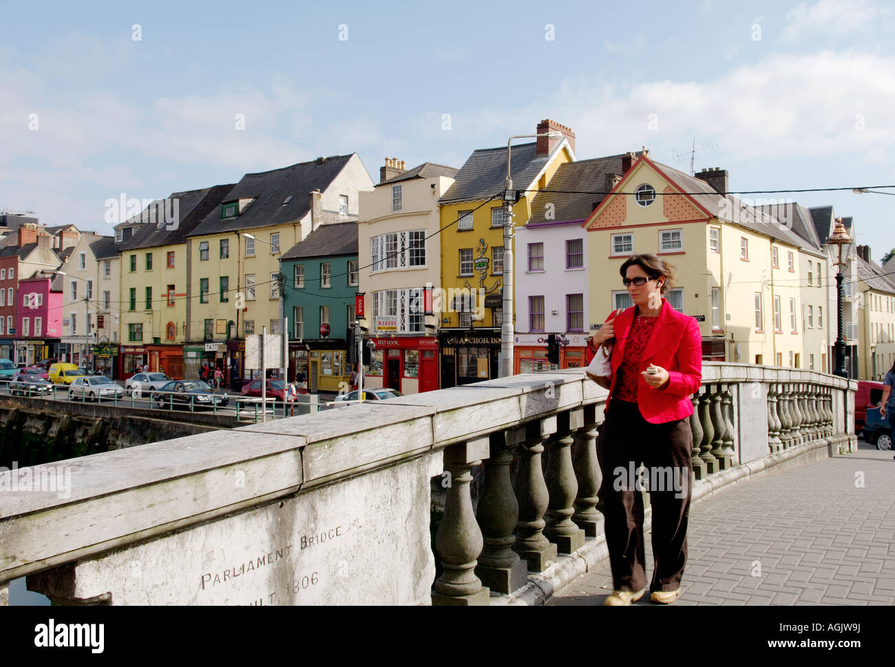 La città di Cork in Irlanda young business woman attraversando il Parlamento ponte sul fiume Lee con vecchi magazzini su Georges Quay dietro. Foto Stock