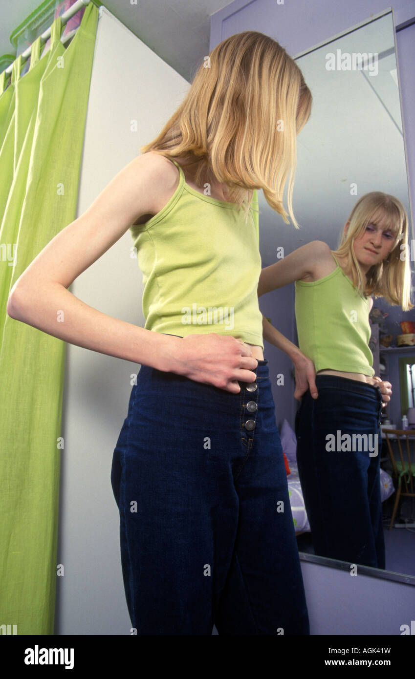 Skinny ragazza adolescente guardando il suo riflesso nello specchio Foto Stock