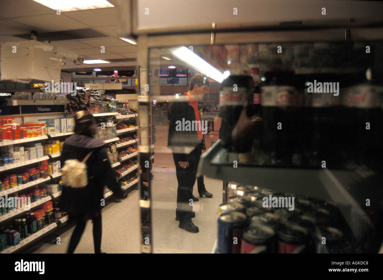 Uomo che naviga a bere in un frigorifero in un supermercato Foto Stock