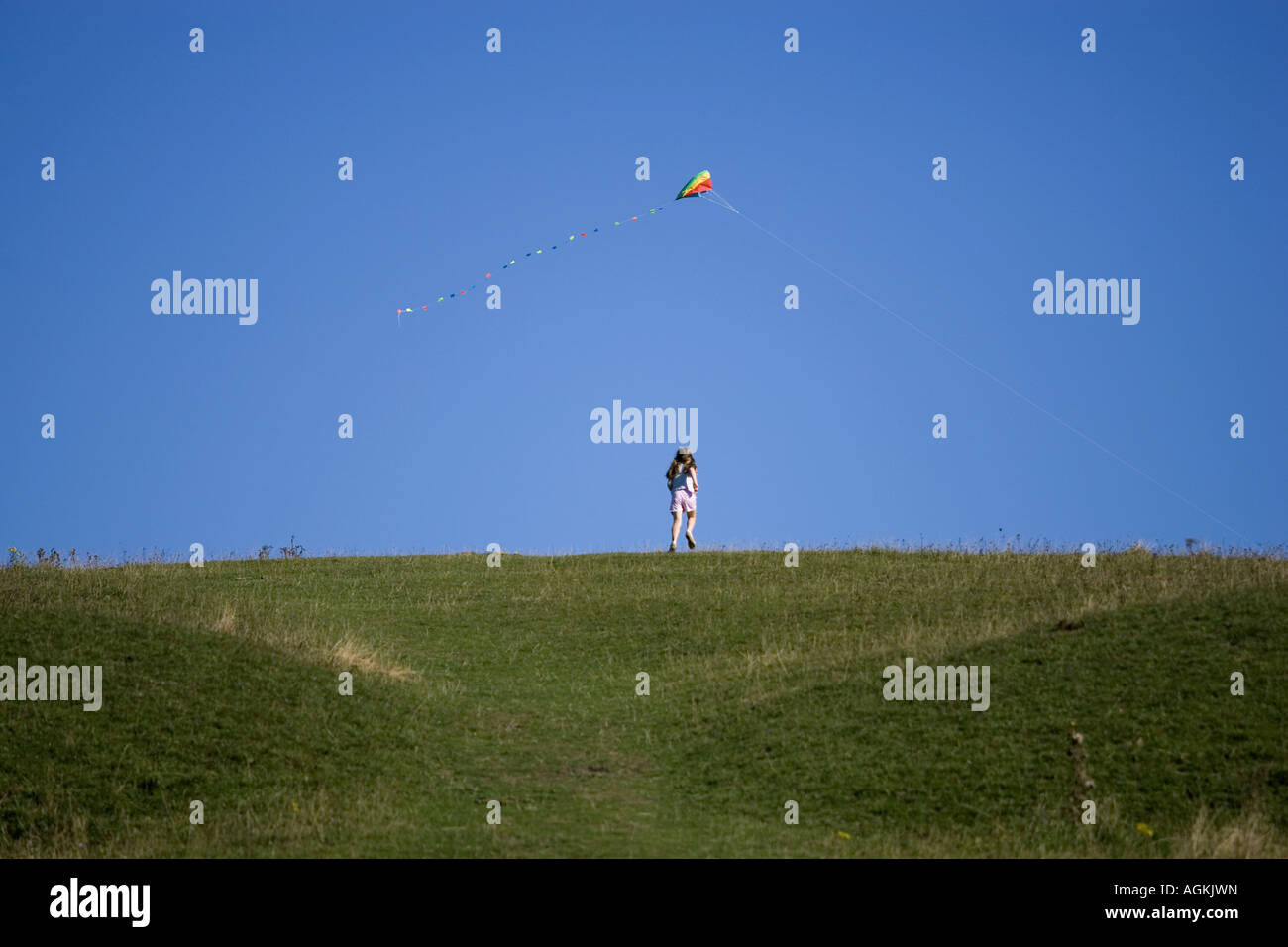 Ragazza e kite su hill top Foto Stock