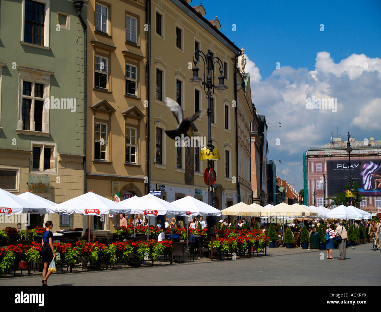 Tavoli all'aperto per bere e mangiare presso le caffetterie e i bar sulla piazza principale di Cracovia in Polonia. Foto Stock