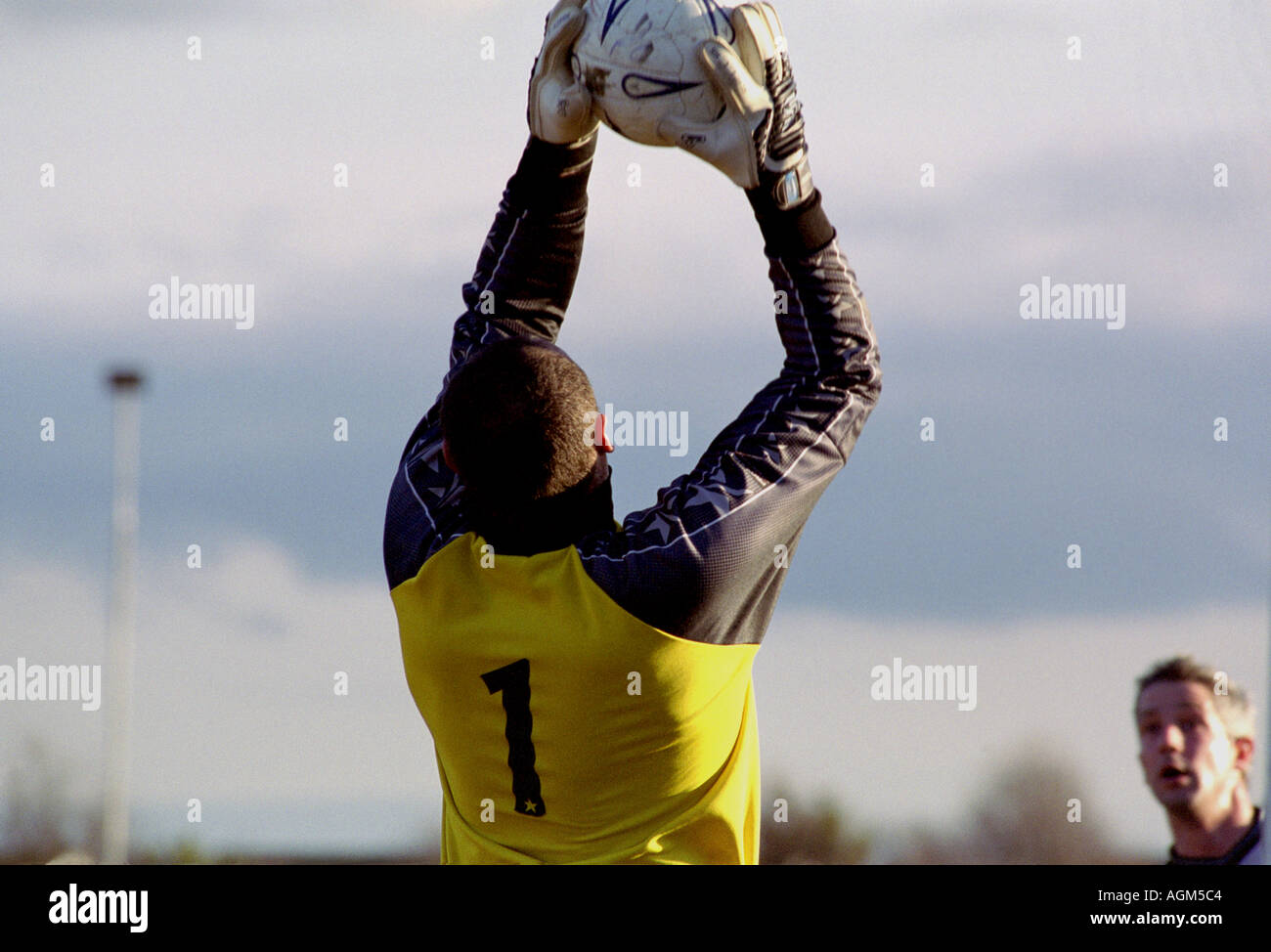Il portiere cattura una palla durante un dilettante partita di calcio, Suffolk, Regno Unito. Foto Stock