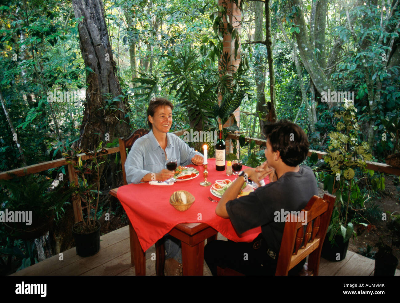 Costa Rica, Monte Verde, Cloud Forest National Park, giovane avente la cena sulla terrazza esterna Foto Stock