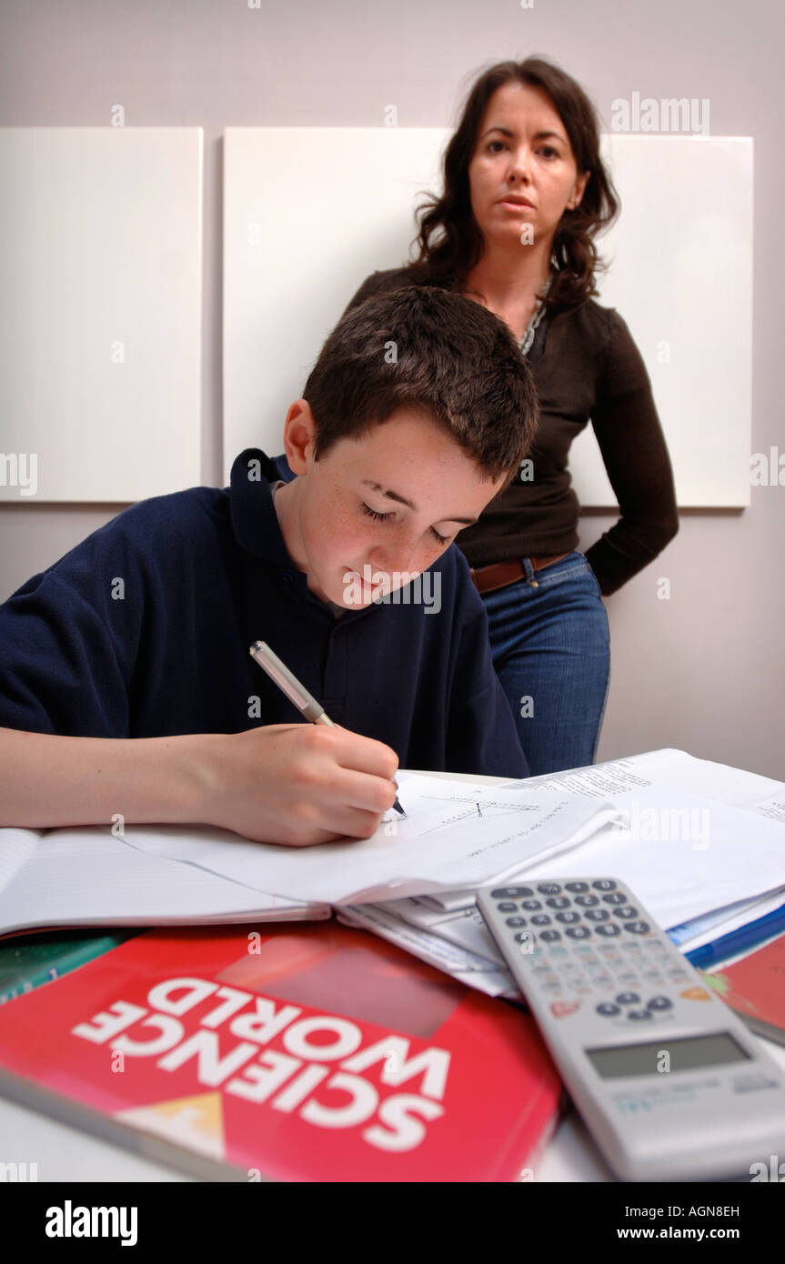 Ritratto di un ragazzo adolescente con la sua scienza compiti e madre cercando sul Regno Unito Foto Stock