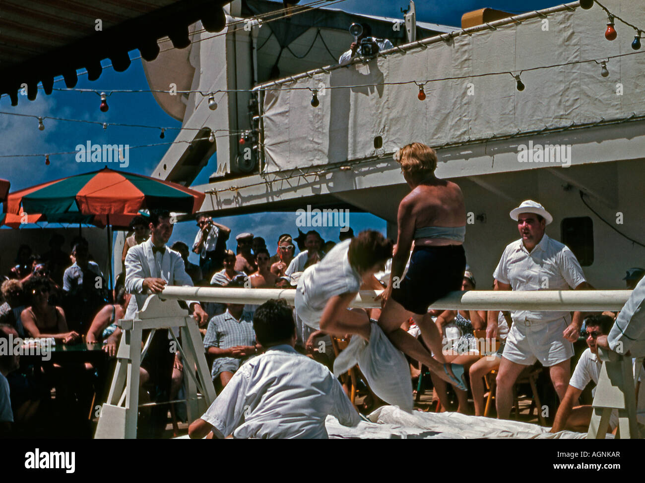 Giochi di coperta - una lotta di cuscino fra due passeggeri femmine sul ponte su una nave da crociera TSS Maasdam della Holland America Line a metà degli anni '50. Foto Stock