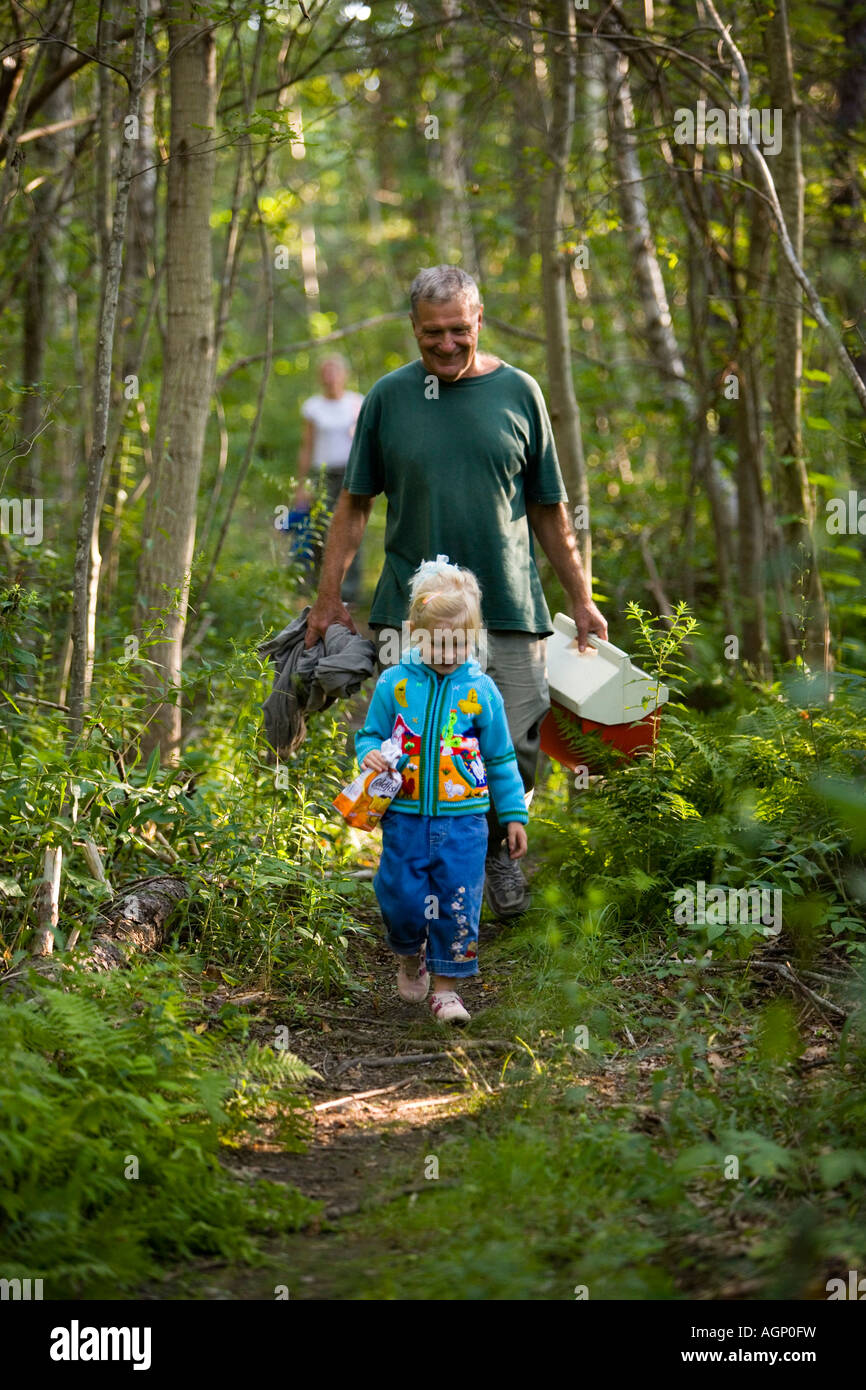 Un uomo cammina con la sua giovane nipote su un sentiero nel bosco in Gloucester Massachusetts Foto Stock