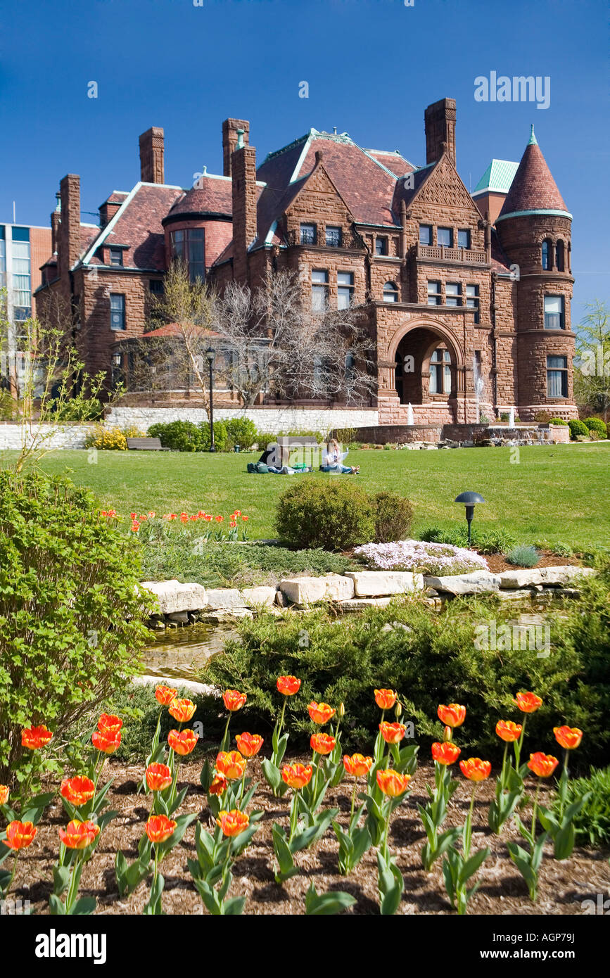 St Louis University Samuel Cupples House in primavera con i tulipani in primo piano e due studenti. Foto Stock