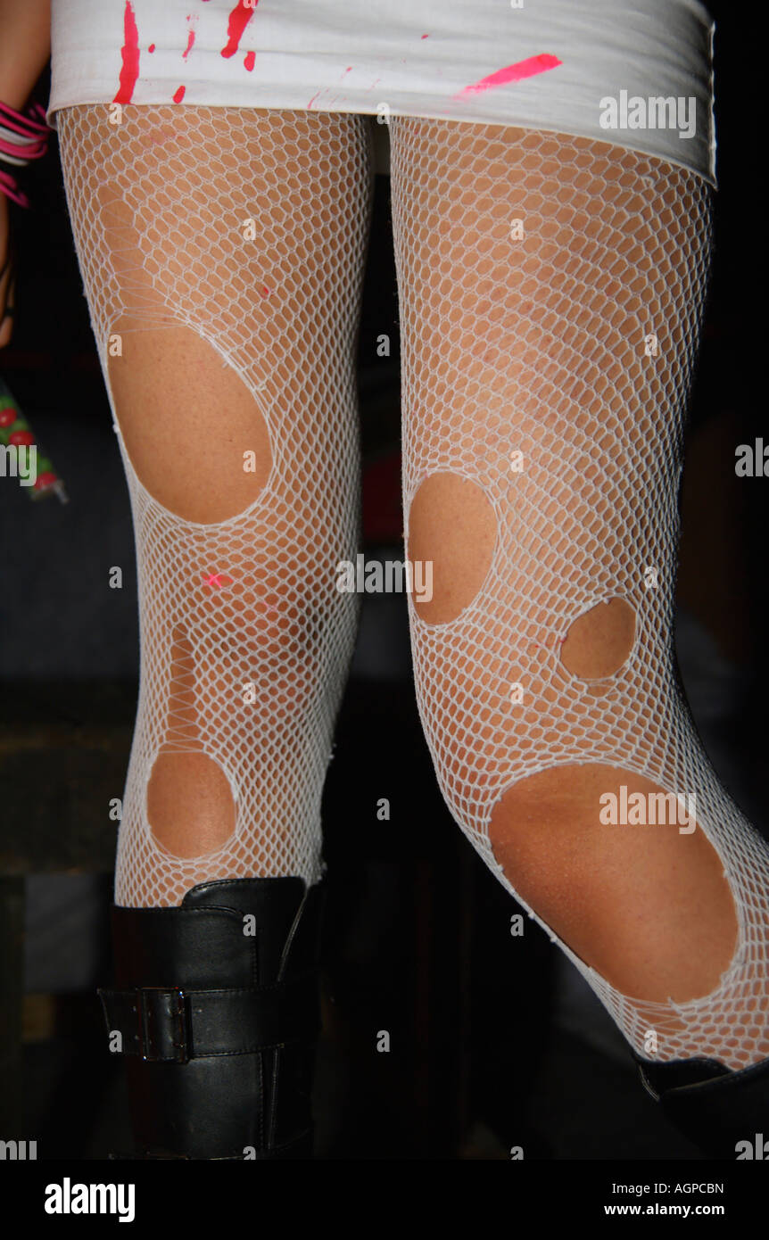 Un giovane modello femminile che indossa un mantello sporco e strappato calze a rete Foto Stock