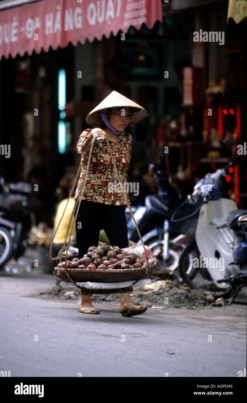Donna vietnamita che trasportano la frutta e la verdura al mercato vecchio Hanoi Foto Stock